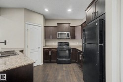 Kitchen featuring wood-finish flooring and dark wood cabinetry - 
