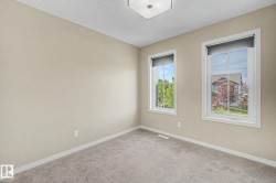 Neutral-toned room with plush carpeting and two windows featuring white trim - 