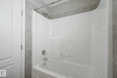 White bathtub and shower combination unit featuring a chrome showerhead and faucet - 315 Watt Boulevard Sw, Edmonton, AB 
