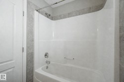 White bathtub and shower combination unit featuring a chrome showerhead and faucet - 