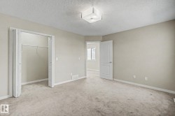 Carpeted interior room featuring neutral wall tones, white baseboards, and a semi-flush ceiling light fixture - 