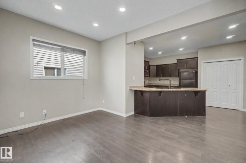 Open-concept living space featuring wood-finish flooring, recessed lighting, and a window with blinds - 315 Watt Boulevard Sw, Edmonton, AB 