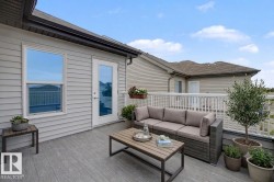 Spacious outdoor deck featuring wood-finish composite decking, white railing, and exterior siding - 