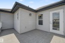 Outdoor patio featuring wood-finish decking, light gray siding, and an exterior door with glass paneling - 315 Watt Boulevard Sw, Edmonton, AB 
