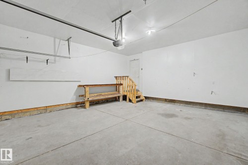 Spacious garage featuring a concrete floor, bright white walls, and a convenient interior access door - 315 Watt Boulevard Sw, Edmonton, AB 