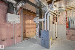 Basement utility area featuring a furnace, water heater, and electrical panel - 
