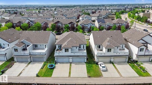 Residential property featuring a light grey exterior, private balcony with white railings, and a two-car garage - 315 Watt Boulevard Sw, Edmonton, AB 