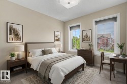 Neutral-toned bedroom featuring two large windows with roller shades, light beige wall paint, and recessed ceiling lighting - 