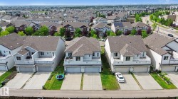 Residential property featuring a light grey exterior, private balcony with white railings, and a two-car garage - 
