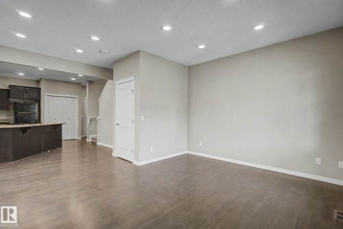 Expansive open-concept living area featuring wood-finish flooring, recessed lighting, and light neutral wall tones - 315 Watt Boulevard Sw, Edmonton, AB 