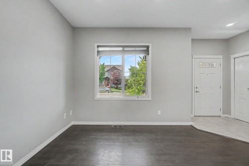 Interior space featuring neutral wall paint, dark wood-finish flooring, and white baseboards - 315 Watt Boulevard Sw, Edmonton, AB 