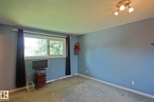 Carpeted room featuring a double window, light blue wall paint, and a track lighting fixture - 3536 104 Street Nw, Edmonton, AB - Indoor Photo Showing Other Room