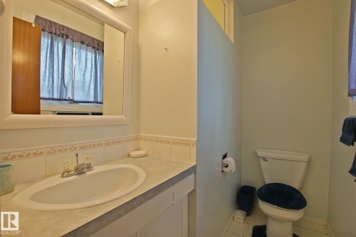 Bathroom featuring a vanity with an integrated sink, a framed mirror, and a toilet - 3536 104 Street Nw, Edmonton, AB - Indoor Photo Showing Bathroom