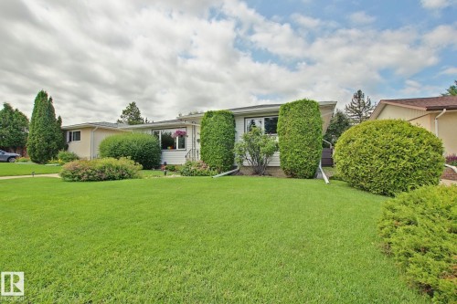 Expansive front lawn with mature shrubbery and established trees - 3536 104 Street Nw, Edmonton, AB - Outdoor