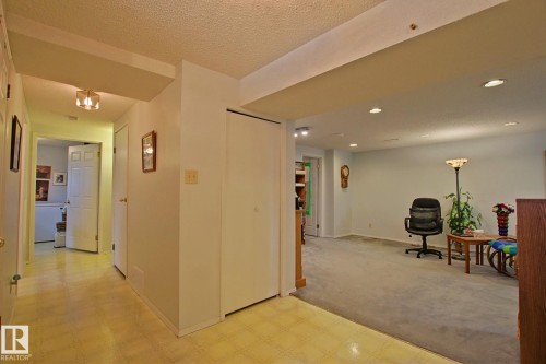 Hallway featuring light-toned resilient flooring and a flush-mount ceiling light fixture - 3536 104 Street Nw, Edmonton, AB - Indoor Photo Showing Other Room
