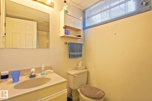 Bathroom featuring a vanity with an integrated sink, wall mirror, and overhead lighting - 3536 104 Street Nw, Edmonton, AB - Indoor Photo Showing Bathroom