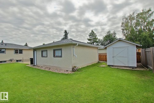 Expansive rear yard featuring a detached shed, a stucco exterior, and mature perimeter trees - 3536 104 Street Nw, Edmonton, AB - Outdoor With Exterior
