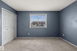 Room featuring blue walls, light carpet, and a white bi-fold closet - 