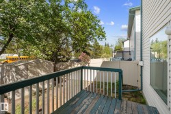 Exterior deck featuring wood-finish decking and white railings - 