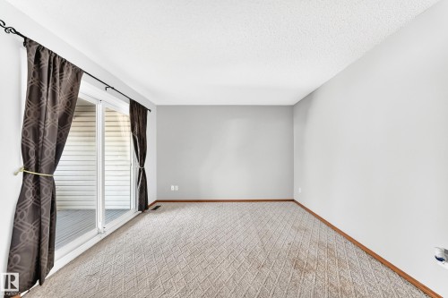 Spacious room featuring light gray walls and patterned carpet flooring - 22 Woodvale Village Nw, Edmonton, AB - Indoor Photo Showing Other Room