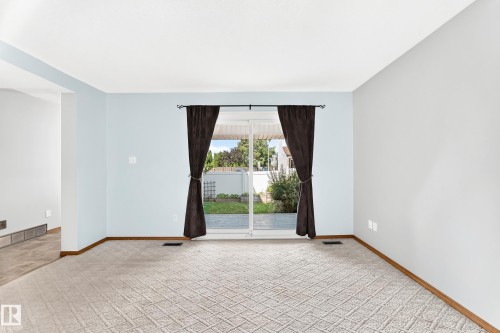 Sliding glass door opening to a private outdoor space - 22 Woodvale Village Nw, Edmonton, AB - Indoor Photo Showing Other Room