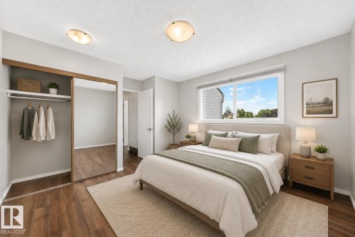 Spacious room featuring wood-finish flooring, a large window, and light-toned walls - 22 Woodvale Village Nw, Edmonton, AB - Indoor Photo Showing Bedroom