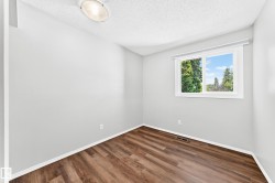 Room featuring light gray walls and wood-finish flooring - 