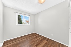 Interior room featuring wood-finish flooring, light grey walls, and white trim - 