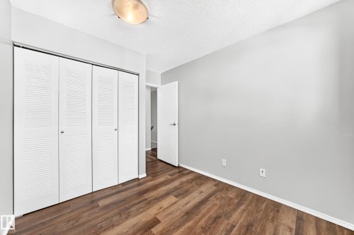Interior room featuring wood-finish flooring, light gray walls, and white baseboards - 22 Woodvale Village Nw, Edmonton, AB - Indoor Photo Showing Other Room