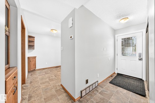 Entryway featuring a white door with decorative glass inserts, an overhead flush-mount light, and tiled flooring - 22 Woodvale Village Nw, Edmonton, AB - Indoor Photo Showing Other Room