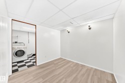 Finished room featuring wood-finish flooring, white walls, and a drop ceiling - 