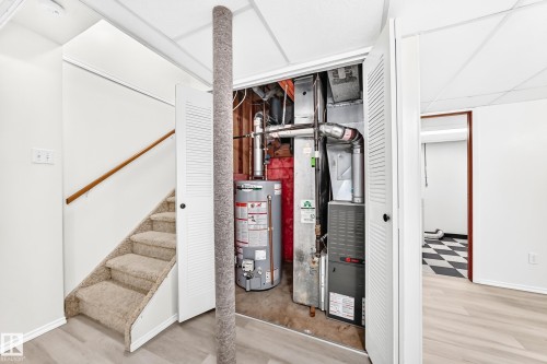 Utility closet with a water heater and furnace, featuring bi-fold louvered doors - 22 Woodvale Village Nw, Edmonton, AB - Indoor Photo Showing Other Room