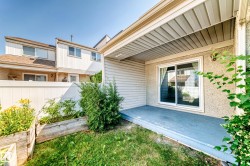 Covered patio featuring a sliding glass door, stucco exterior, and painted wood deck - 