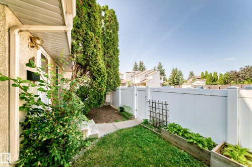 Private outdoor patio with a white privacy fence and a manicured lawn - 22 Woodvale Village Nw, Edmonton, AB - Outdoor