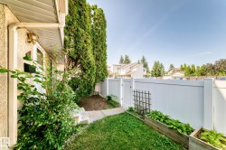 Private outdoor patio with a white privacy fence and a manicured lawn - 