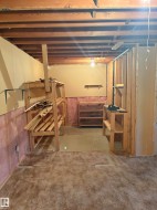 Unfinished basement space featuring exposed wood joists and structural framing - 