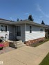 Exterior featuring light grey siding, brick detailing, a concrete walkway, and a concrete entry staircase with a metal handrail - 17520 Callingwood Road Nw, Edmonton, AB  - Outdoor 