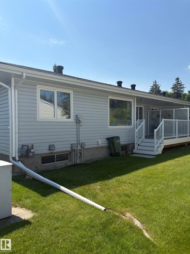 Rear exterior featuring light-colored siding and a multi-level deck with white railings - 17520 Callingwood Road Nw, Edmonton, AB - Outdoor With Exterior