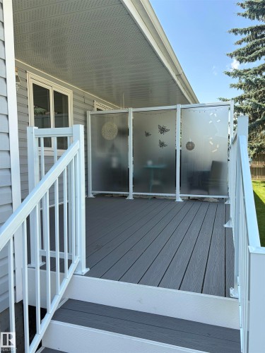 Spacious composite deck with white railings and privacy screens - 17520 Callingwood Road Nw, Edmonton, AB - Outdoor With Deck Patio Veranda With Exterior