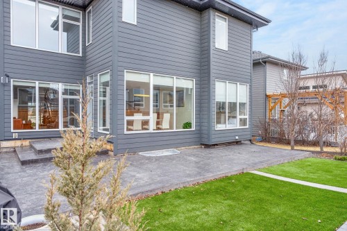 Modern gray exterior with multiple large windows - 1313 Hainstock Way Sw, Edmonton, AB - Outdoor With Deck Patio Veranda