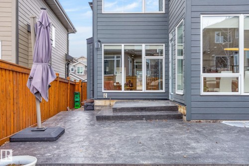 Rear exterior featuring modern gray siding and white-framed windows - 1313 Hainstock Way Sw, Edmonton, AB - Outdoor