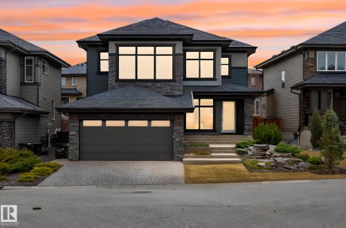 Contemporary two-story residence featuring a dark facade with stone accents and a multi-pane front window - 1313 Hainstock Way Sw, Edmonton, AB - Outdoor With Facade