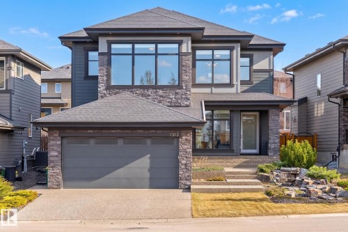Contemporary two-story exterior featuring stone accents and dark siding - 1313 Hainstock Way Sw, Edmonton, AB - Outdoor With Facade