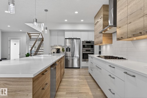 Modern kitchen featuring white countertops, stainless steel appliances, and a gas cooktop - 1313 Hainstock Way Sw, Edmonton, AB - Indoor Photo Showing Kitchen With Upgraded Kitchen