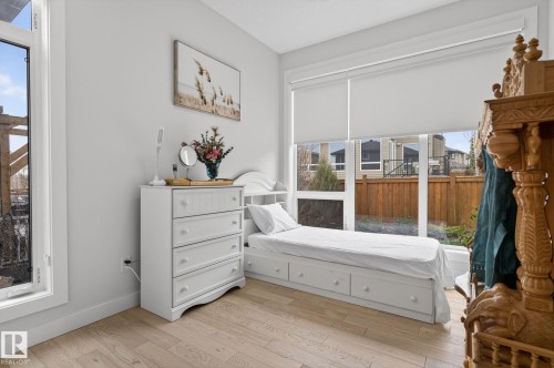 Light wood-finish flooring complements the neutral wall color - 1313 Hainstock Way Sw, Edmonton, AB - Indoor Photo Showing Bedroom