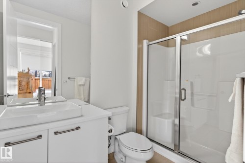 Contemporary bathroom featuring a white vanity with an integrated rectangular sink, chrome faucet, and under-cabinet storage - 1313 Hainstock Way Sw, Edmonton, AB - Indoor Photo Showing Bathroom