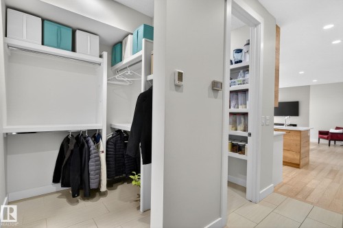 Custom closet system with multiple hanging rods and shelving - 1313 Hainstock Way Sw, Edmonton, AB - Indoor