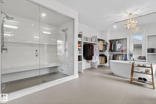 Spacious bathroom featuring a glass-enclosed shower with dual showerheads and an integrated bench - 1313 Hainstock Way Sw, Edmonton, AB - Indoor