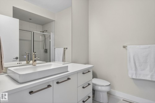 Modern bathroom featuring a rectangular vessel sink, white vanity with multiple drawers, and brushed nickel hardware - 1313 Hainstock Way Sw, Edmonton, AB - Indoor Photo Showing Bathroom