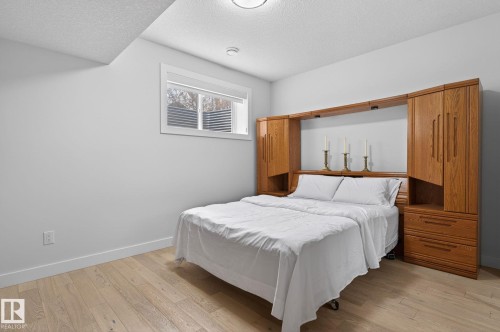 Neutral wall paint with wood-finish flooring - 1313 Hainstock Way Sw, Edmonton, AB - Indoor Photo Showing Bedroom